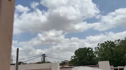 Timelapse of White Clouds Moving Across Blue Sky Above Urban Rooftops and Trees Stock-Footage 331645827
