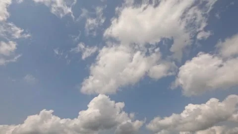 Timelapse of white clouds moving in a clear blue sky Stock Footage 323148802