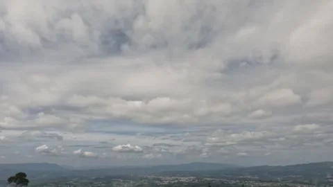 Timelapse of white clouds moving quickly in the blue sky over the countrysid Stock Footage 307419074