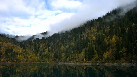 Timelapse of white clouds over clear autumn mountain lake Vídeos de archivo 70759602