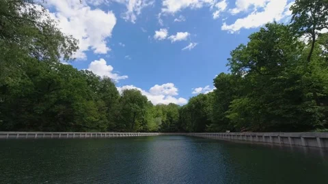 Timelapse of white clouds over a lake in a park Stock Footage 130929210