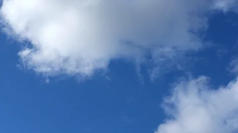 Timelapse of white clouds running on a blue sunny sky. Stock Footage 129948554