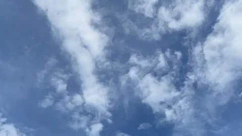 Timelapse of white cumulus clouds moving in a bright blue sky Stock Footage 295941461