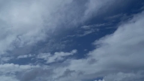 Timelapse of white fluffy cumulus clouds moving against a blue sky. Stock Footage 129681712