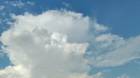 Time‑lapse White Fluffy Cumulus Clouds Over Clear Blue Sky 動画素材 311381880