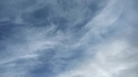 Timelapse of white to gray cirrus clouds blowing across a blue summer sky Stock Footage 310215210