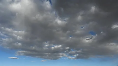 Timelapse of white to gray summer clouds moving away from the viewer in a bright Stock Footage 312075156