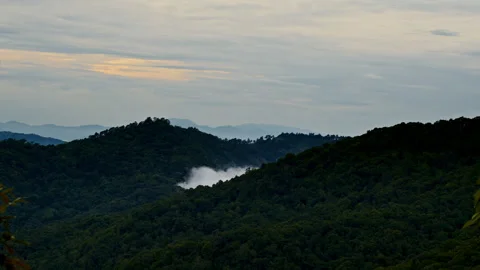 Timelapse of the white haze cloud appears from behind the dark hill Stock Footage 261493417