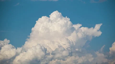 Timelapse of white puffy cumulus clouds forming on summer blue sky. Moving and Stock Footage 168876569