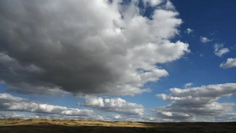 Timelapse of white summer clouds above a dry western landscape with a campground Stock Footage 303379924