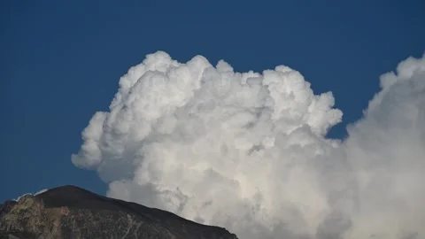 Timelapse of White Summer Clouds Billowing Above Mountains Under a Bright Blue Stock Footage 331683992