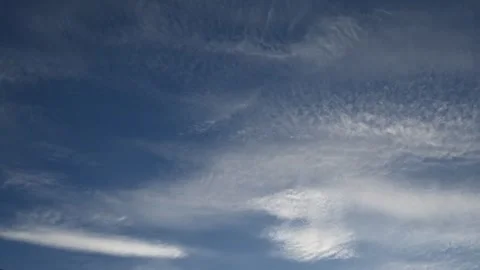 Timelapse of white summer clouds moving across a pristine blue sky Stock Footage 331222740