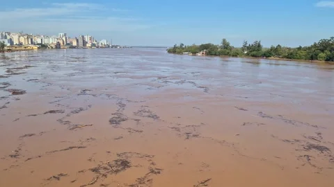 Timelapse of a wide dirty river carrying floating debris and pollution Stock Footage 346330406