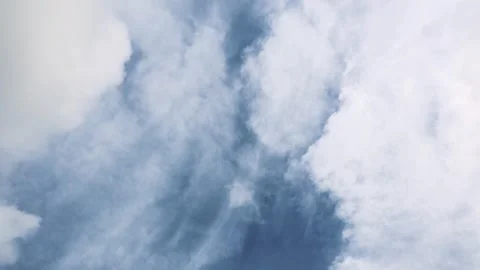 Timelapse of windsheer clouds traveling in different direction on a blue sky Stock Footage 262684321
