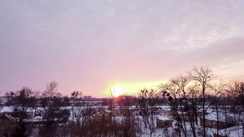 Timelapse, winter sunset over the snow-covered city, dark outlines of bare trees Stock Footage 107462309
