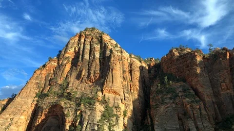 Timelapse of wispy clouds blowing over huge mountain cliff faces in Zion Park Video stock 113944073