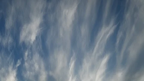 Timelapse of wispy white summer clouds gliding across a bright blue sky Stock Footage 342280670