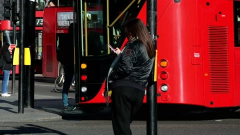 Timelapse. Woman checking her mobile in the middle of a busy road. London Stock Footage 170286623