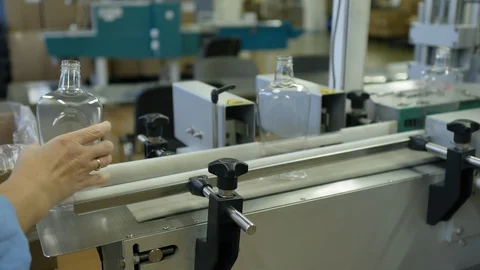 Timelapse of worker put plastic bottles on a conveyor belt. 库存影片 128455057