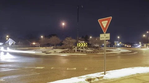 Timelapse of a Yield Sign and Roundabout Traffic at Night Stock Footage 85574951