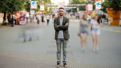 Timelapse of Young man standing still at sidewalk in crowd traffic stream with Stock Footage