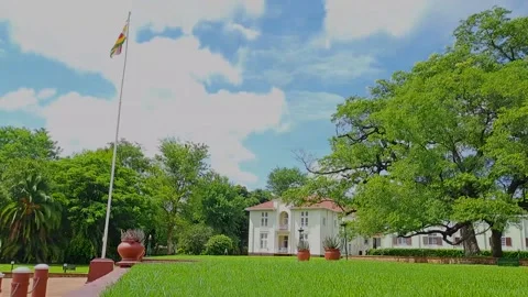 A timelapse of the Zimbabwe flag with the scenic view of Victoria Falls Hotel. Stock Footage 303058092