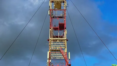 Timelapse with Zoom In on Red Industrial Tower Against Dramatic Sky Stock Footage 337689249