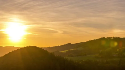 Timelapse zoomed by the setting sun over the top hill Stock Footage 145604410