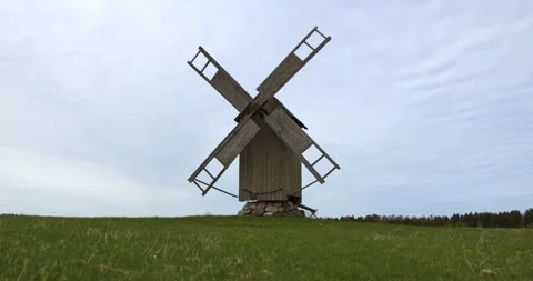 Timeless grain mill amidst lush summer landscape. Stock Footage 246439098