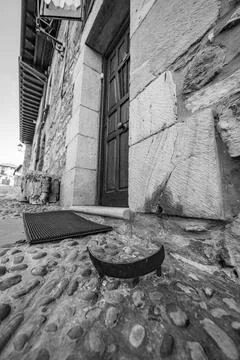 Timeless iron boot scraper by historic stone house in black and white Stock Photos