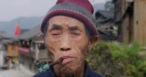 Timeless portrait of a real unique authentic Asian Chinese village man smoking a Stock Footage 201094338