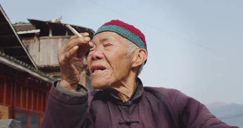 Timeless portrait of a real unique authentic Asian Chinese village man smoking a Stock Footage 201095726