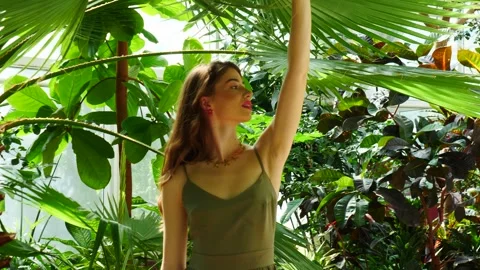 A Timeless Woman Posing Gracefully and Elegantly Amidst Lush, Vibrant Greenery Stock Footage 311409508