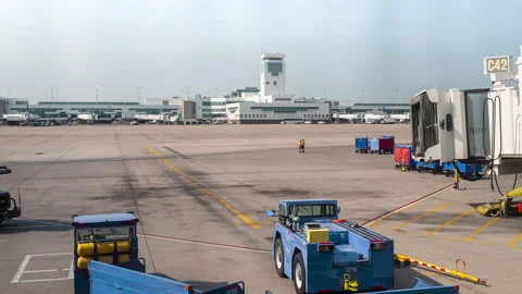 Timelpse plane pulling into jet bridge at airport with workers and vehichles Stock Footage 157524820