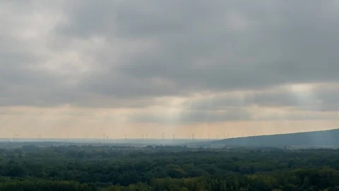 Timelpse of silhouettes of wind turbines under moving sun rays Stock Footage 118167653