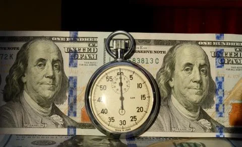 The timer on the background of dollar bills (time - money, income, loan - con Stock Photos