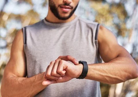 Timer ready, lets go. an unrecognizable man standing alone and setting a timer Stock Photos