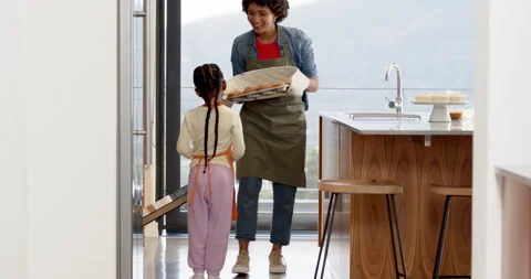 Timer ringing, Diverse mother and daughter sliding tray of rolls from oven Stock Footage 314539121