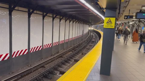 Times Square Shuttle Train Rounds Curve Into Station Past Striped Platform Wall Stock Footage 347896082