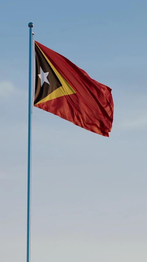 Timor-Leste, Dili: Cinematic Vertical Waving National Flag Against Blue Sky Stock Footage 323081585