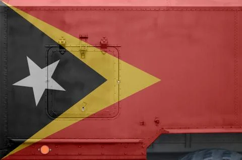 Timor Leste flag depicted on side part of military armored truck closeup. Arm Stock-Fotos