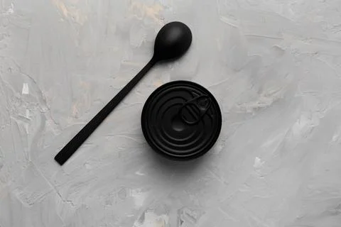 Tin can and spoon on gray background top view Stock Photos