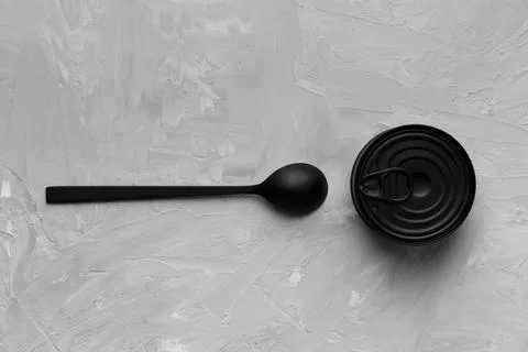 Tin can and spoon on gray background top view Stock Photos