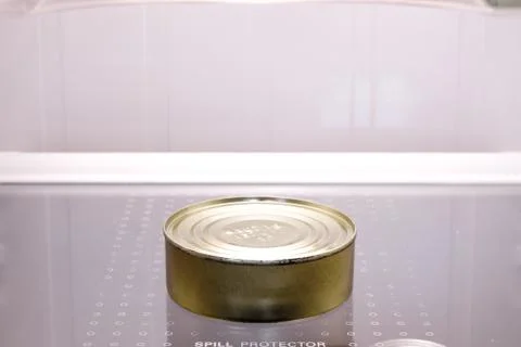 Tin can in empty fridge Stock Photos