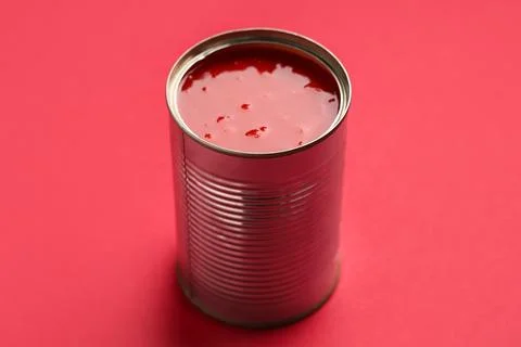 Tin can of tasty tomato paste on red background Stock Photos