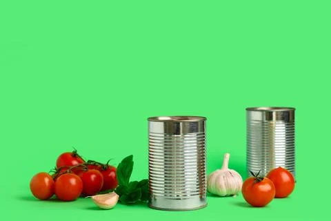 Tin can with tomato paste and ingredients on green background Stock Photos