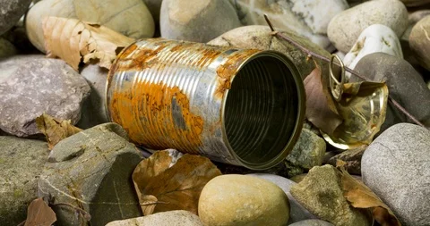 Tin can waste on pebble beach floor closeup Stock Footage 105700705