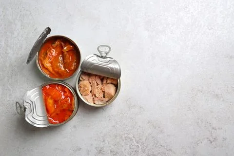 Tin cans with fish on grey table, flat lay. Space for text Foto stock