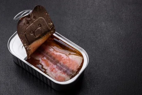 Tin or aluminum rectangular can of canned salmon with a key on a dark concret Stock Photos