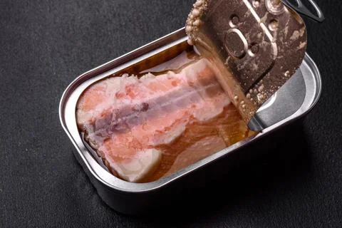 Tin or aluminum rectangular can of canned salmon with a key on a dark concret Stock Photos